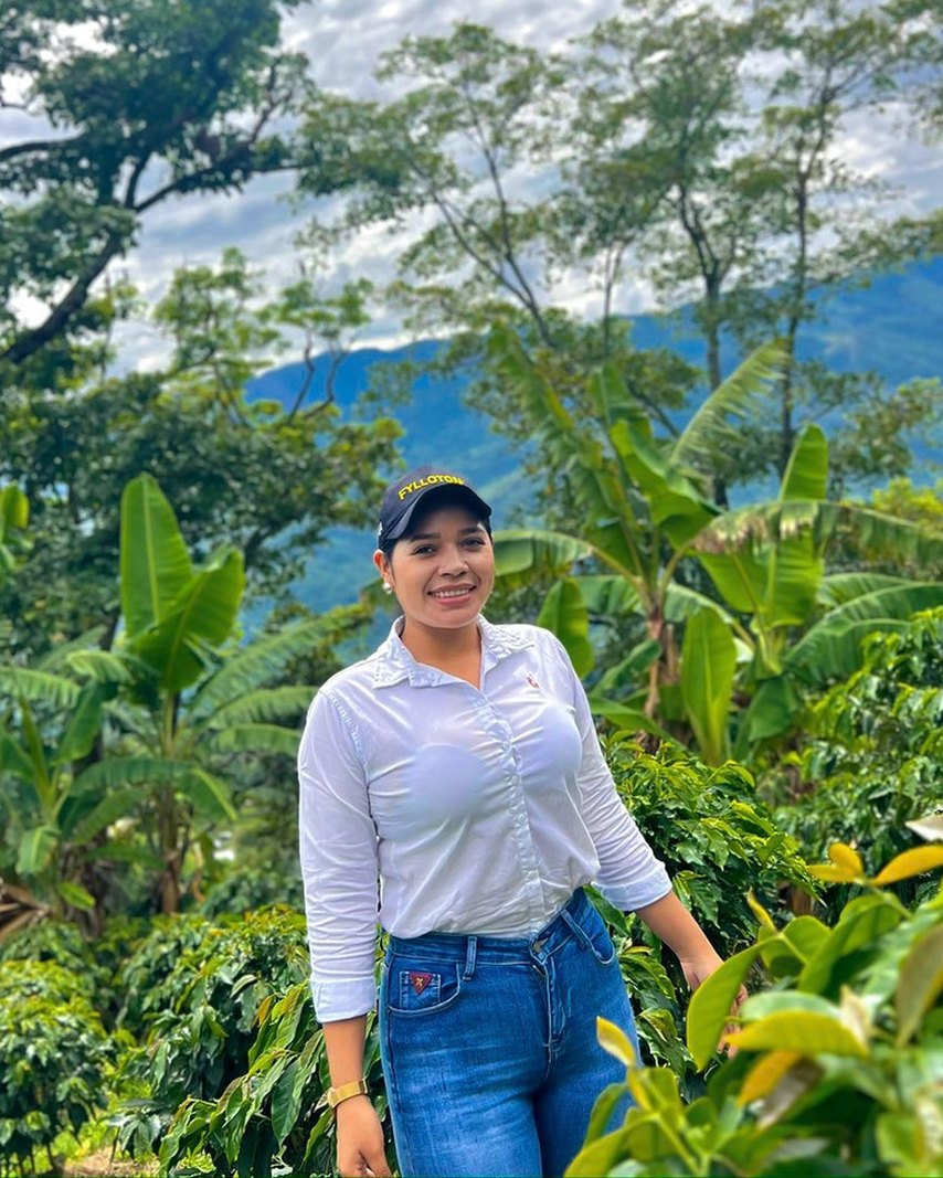 Carolina Perdomo standing among coffee plants on Finca Villa Esperanza in Colombia