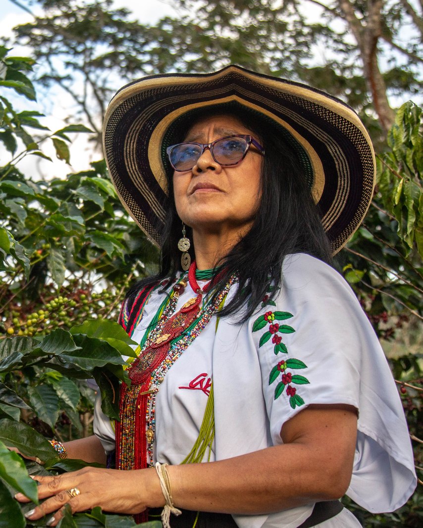 Aurora María Izquierdo Torres standing among her coffee trees in the Sierra Nevada de Santa Marta, Colombia